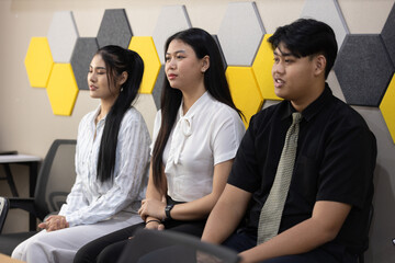 Three candidates prepare for job interview at contemporary office. They display mix of anticipation...