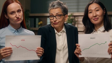 Mature businesswoman leader confused multiethnic women in office Caucasian girl holding chart bad...