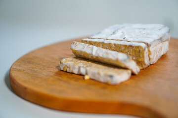 Tempeh that has been cut into pieces on a wooden cutting board