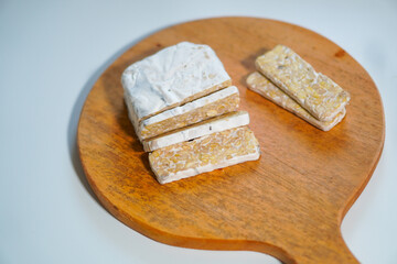 Tempeh that has been cut into pieces on a wooden cutting board