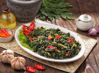 Tumis Daun Pepaya. Sauteed papaya leaves are papaya leaves sautéed with garlic, shallots and red chilies