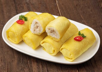 Semar Mendem is an Indonesian savoury snack made of glutinous rice filled with seasoned shredded chicken, fish abon (meat floss) or serundeng wrapped in a thin omelet