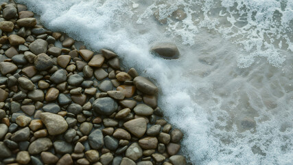 A rocky shoreline with a foamy wave crashing against the rocks