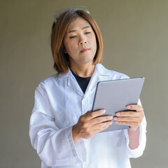 Confident transgender non-binary person in lab coat and protective glasses