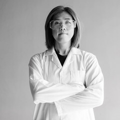 Confident transgender non-binary person in lab coat and protective glasses
