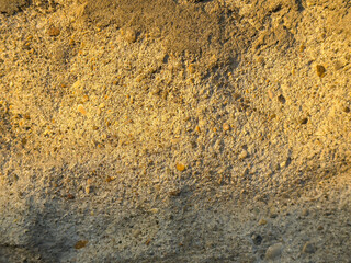 Textured surface of old weathered concrete wall with small pebbles