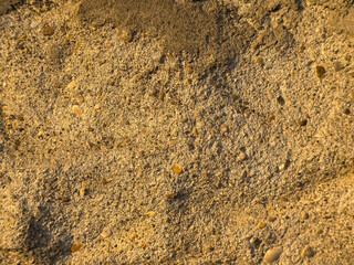 Close-up of rough sandy beach texture with small pebbles