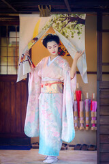 Pretty young Asian Japanese woman in a Traditional Furisode Kimono Yukata dress costume. A young...