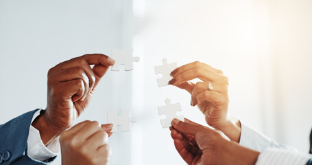 Hands, business people and puzzle for team at office with solution, synergy and strategy at...