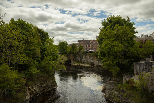 Fergus - town in Ontario on the Grand River, popular tourist town with beautiful old stone houses, a waterfall, and ancient bridges. A tourist magnet. Summer sunny day with cloudy sky. Ontario, Canada