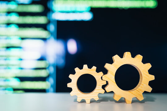 Two wooden gears sit on a table, juxtaposed against a background of business data, symbolizing the intricate system required for accurate, precise, and sufficient data.