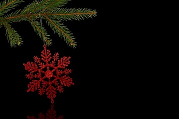 3D art showing red glittery snowflake ornament hanging on pine branch over black surface copy space © vectorfusionart