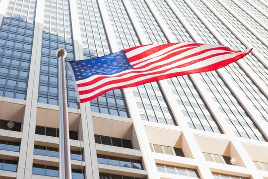 Fototapeta American flag against sky scraper