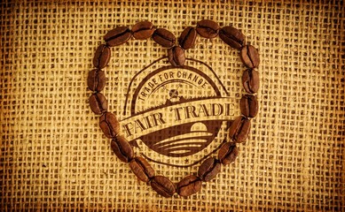 Heart-shaped coffee bean arrangement is being shown on flat design burlap, with fair trade stamp