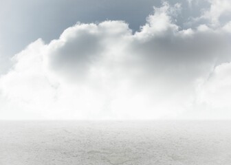 Cloud formation is stretching across horizon in flat seascape with pale ripples reflecting light