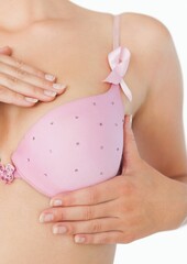 Mid section of woman in bra with breast cancer awareness ribbon