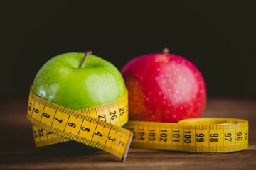 Red and green apples with measuring tape