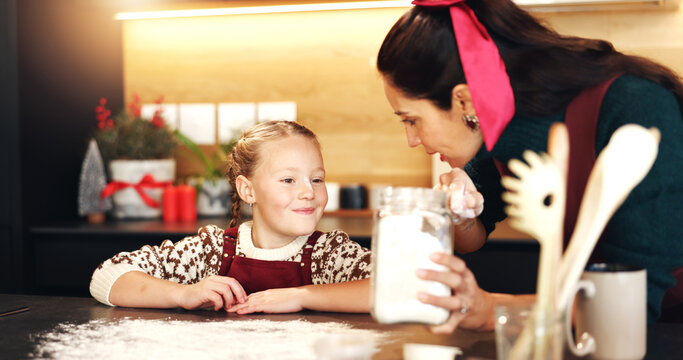 Mom, girl and cooking with flour at Christmas with smile, teaching and ingredients for cookies in home. People, mother and daughter in kitchen, learning or bonding with baking at xmas in family house - Powered by Adobe