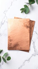 Polished Copper Sheet With Patina Spots Texture Against Marble Background and Green Foliage Accents