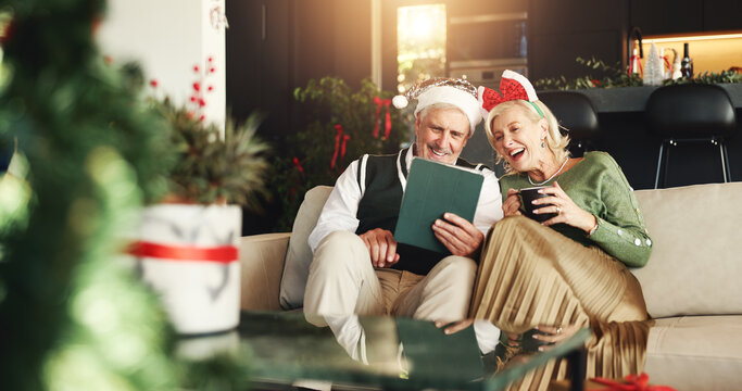 Christmas, coffee and old couple on sofa, tablet or bonding together with social media, festive or app. Home, Xmas or man with woman, tradition or eggnog with online entertainment, love or holiday