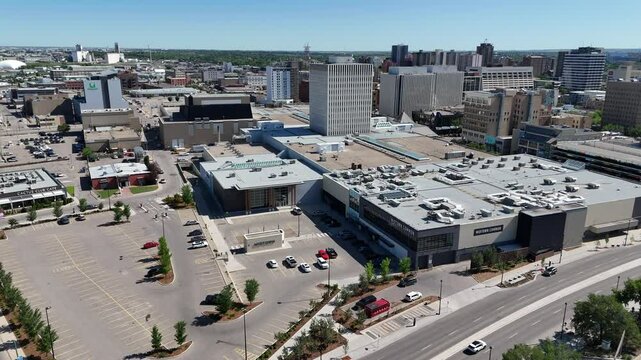 City street with a large shopping mall in the background. The mall is empty and the street is mostly empty as well