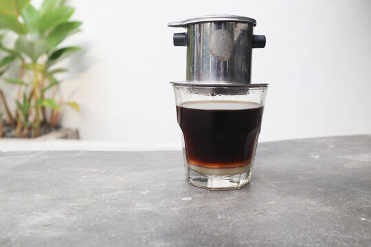 Vietnamese drip, Vietnamese coffee with condensed milk in glass cups and traditional metal coffee maker phin. Traditional method of making of vietnamese coffee. served on outdoor