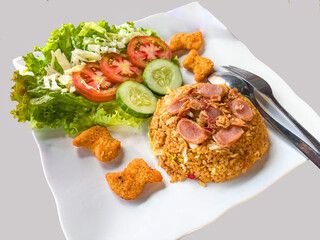 ried rice or nasi goreng is is a food made from fried rice originating from Asia served cucumber, sausage, nuggets, tomatoes. isolated on white background