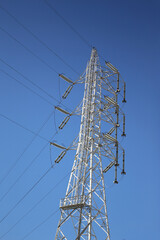 High-voltage transmission tower in Japan under clear blue sky.