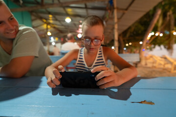 Boy using phone on seaaside