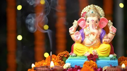 A beautiful idol of Lord Ganesha is placed on a decorated altar during Ganesh Chaturthi, surrounded by marigold flowers, diyas (oil lamps), and incense smoke.