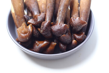 Termite mushrooms with long stems, white tips, and dark brown caps.