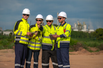 Photo group of oil refinery process engineers team working outdoor in petrochemical fieldwork