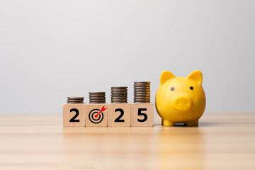 Yellow piggy bank with stacked coins and wooden blocks showing 2025 and target icon, representing saving money, financial planning, investment strategy, wealth management and business growth goals