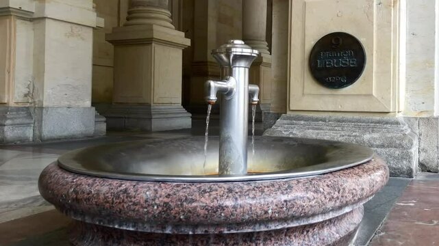 Healing mineral water flowing from a natural hot spring. Mill Colonnade. Karlovy Vary, Czech Republic.