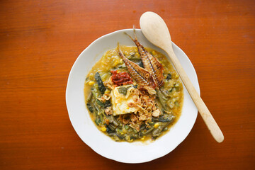 bubur manado or Tinutuan Porridge is tradisional porridge. Manadonese rice porridge, mixed with pumpkin, corn, vegetables. Served with tofu salted fish and chili sauce or sambal