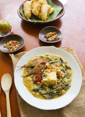 bubur manado or Tinutuan Porridge is tradisional porridge. Manadonese rice porridge, mixed with pumpkin, corn, vegetables. Served with tofu salted fish and chili sauce or sambal