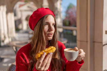 Woman Beret Coffee: Woman enjoys coffee & eclair outside, sunny day, in city cafe, enjoying a treat.