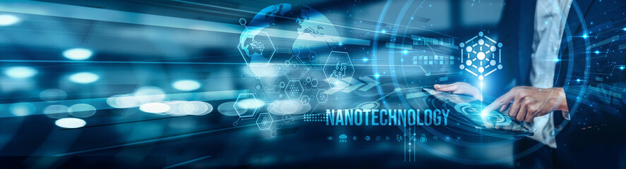 A businessman using a tablet is analyzing nanotechnology by exploring its applications in...