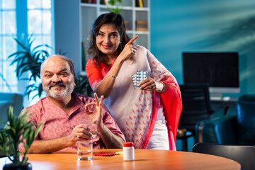 Elderly Indian couple taking medicine and managing health with daily medication and care routine