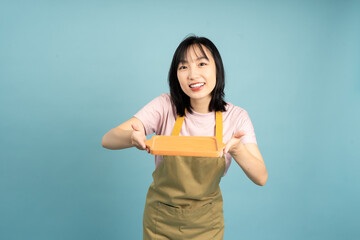 Young woman presents a tray with a smile in a bright, modern setting showcasing creativity and joy...