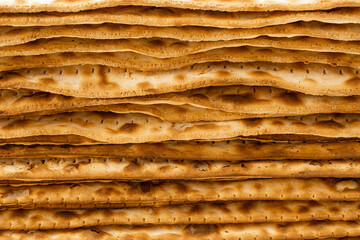 Close-Up View of Stacked Traditional Jewish Matzah Bread - Layered Texture of Unleavened Passover...