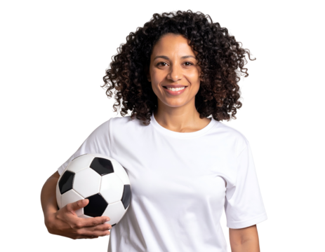 Joyful female athlete with expressive curly hair poses confidently with a traditional soccer ball.