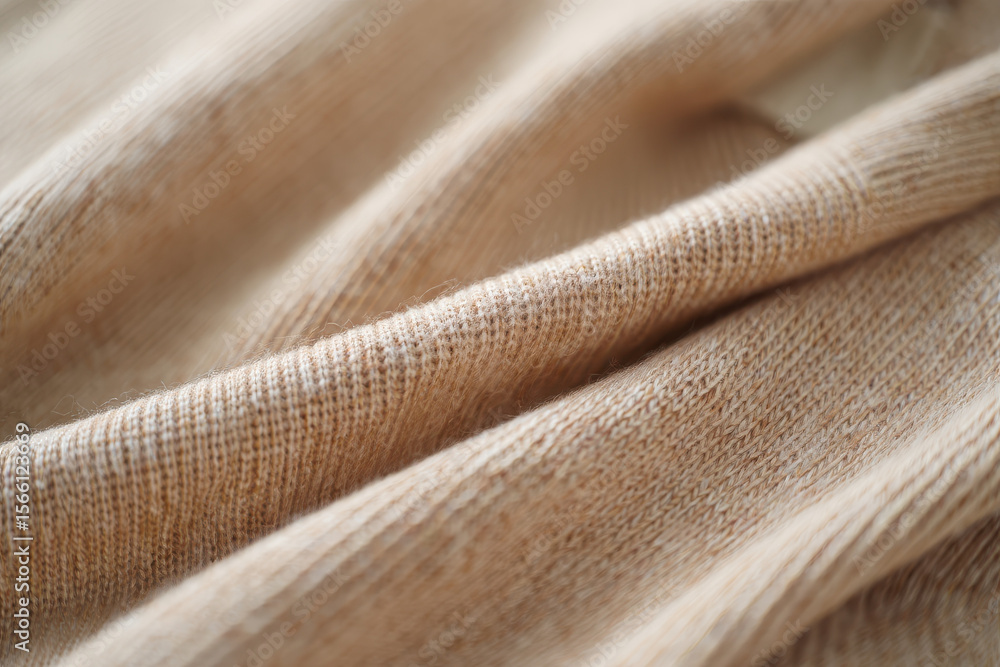 Poster close up shot of a beige colored fabric with visible texture and soft folds creating light and shado
