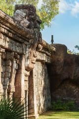 ancient stone sculpture in the shape of a human face on an exterior wall