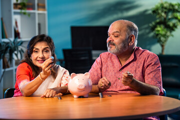 Elderly Indian couple managing savings with coins and piggy bank, planning secure financial future