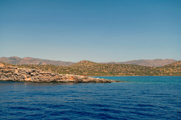 Scenic coastline of Crete observed from the crystal-clear waters on a sunny day