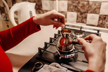 Coffee Brewing Turkey Stovetop Kitchen: Woman prepares traditional coffee on gas stove.