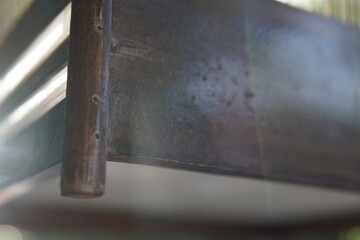 Close-up of a rustic wooden bed frame with visible texture and joinery details
