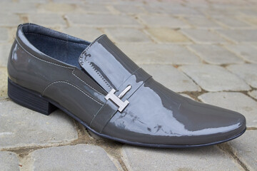 lacquer grey men's shoes, Varnished leather shoes that are both modern and fashionable are seen on cobblestones.