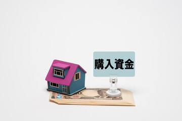 家の模型と一万円札と購入資金の文字